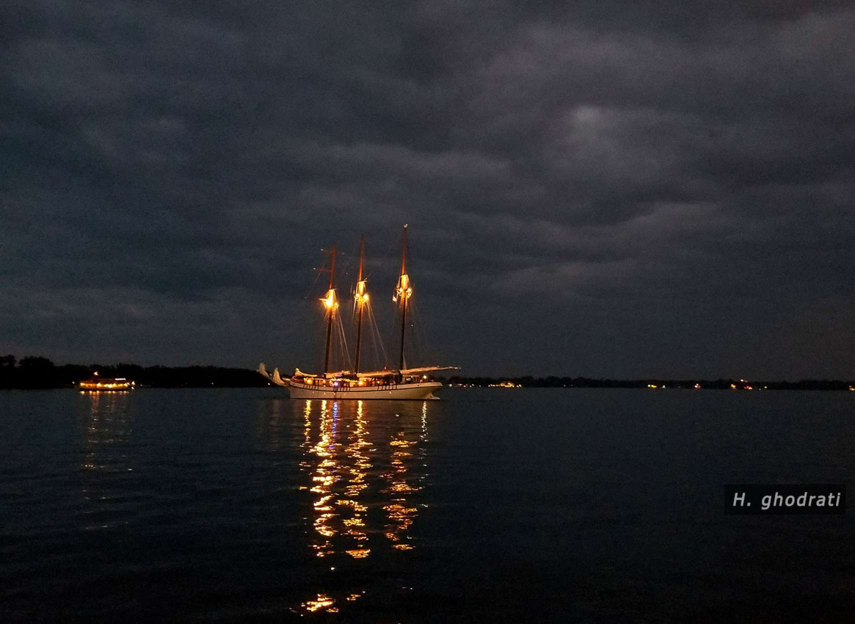 شبی ابری و قایقی با چراغ‌هایش